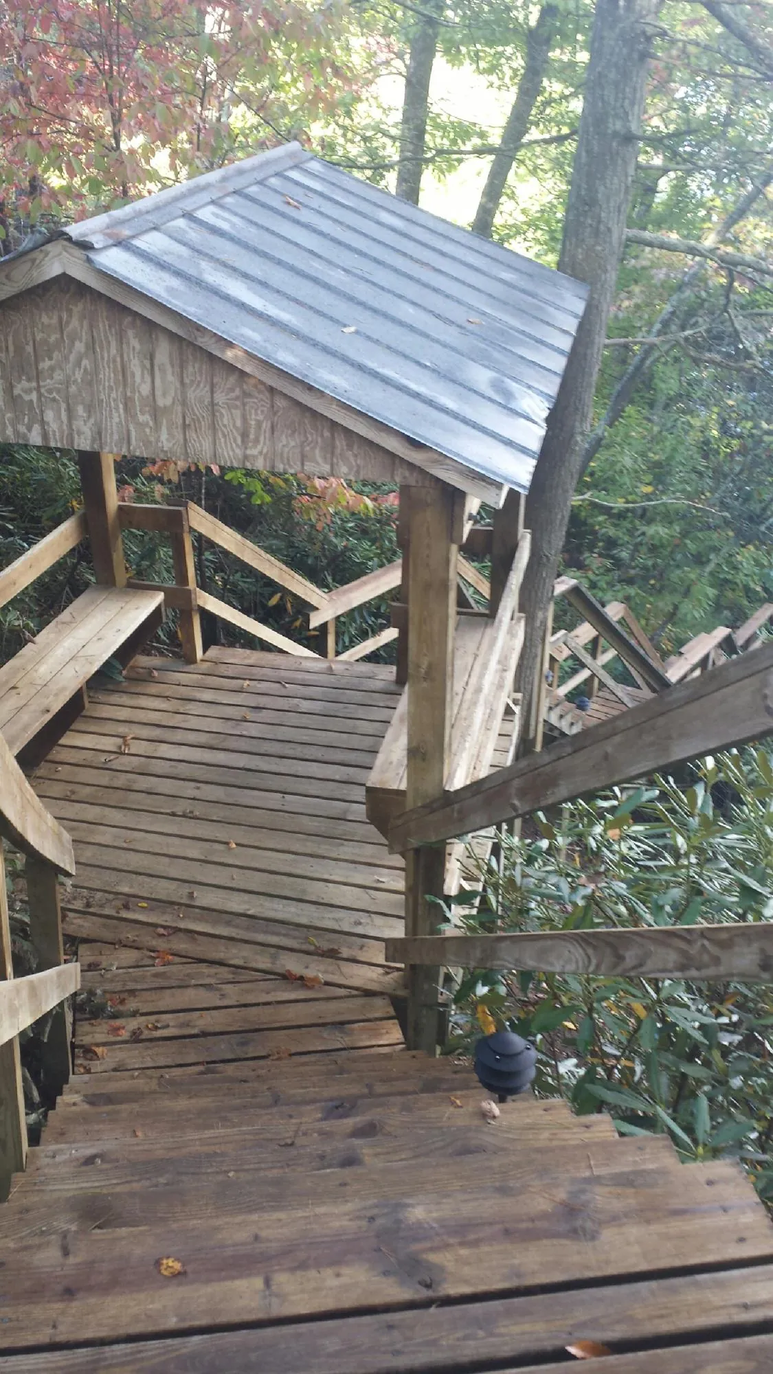Metal roofed shelter over wooden steps on a wooded walkway — Skylight Repair & Installation work by our crew in Fairfield